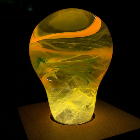 Glass vase with orange and yellow swirls on a dark background