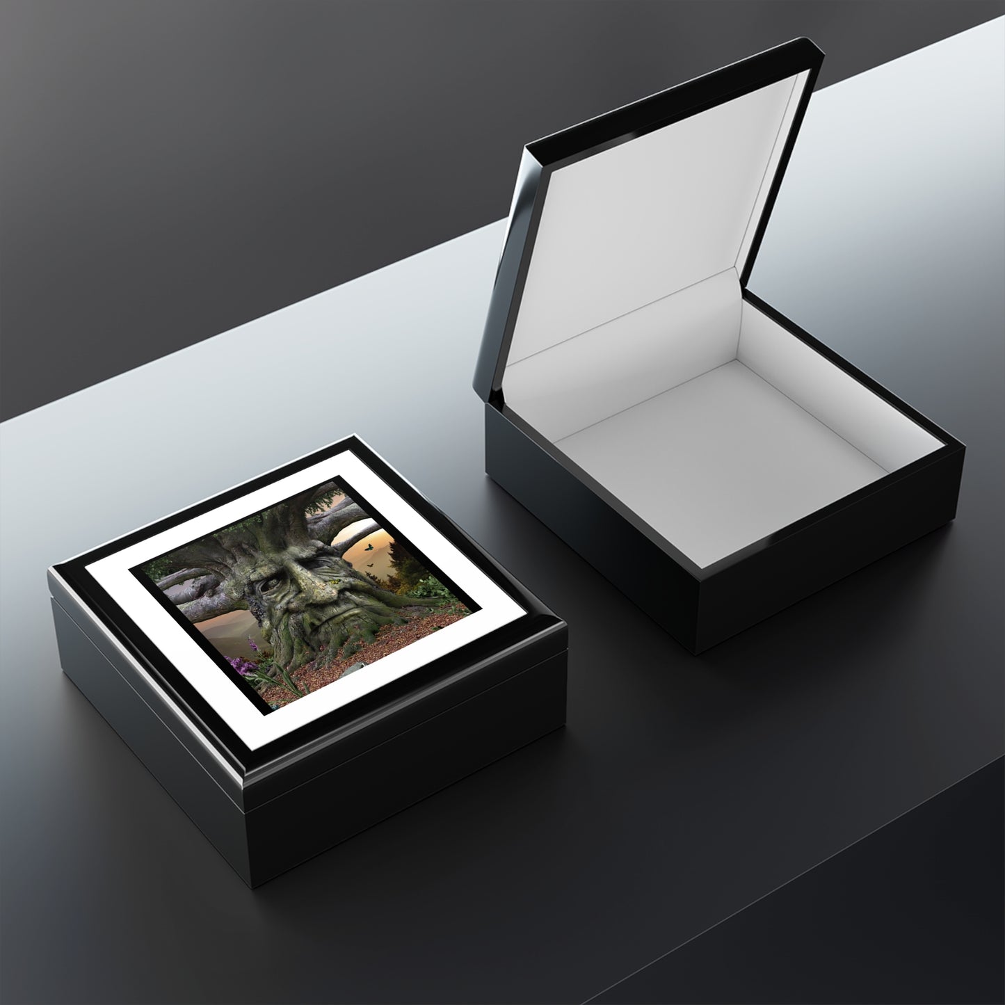 Black jewelry box with a white interior, open on a reflective surface.