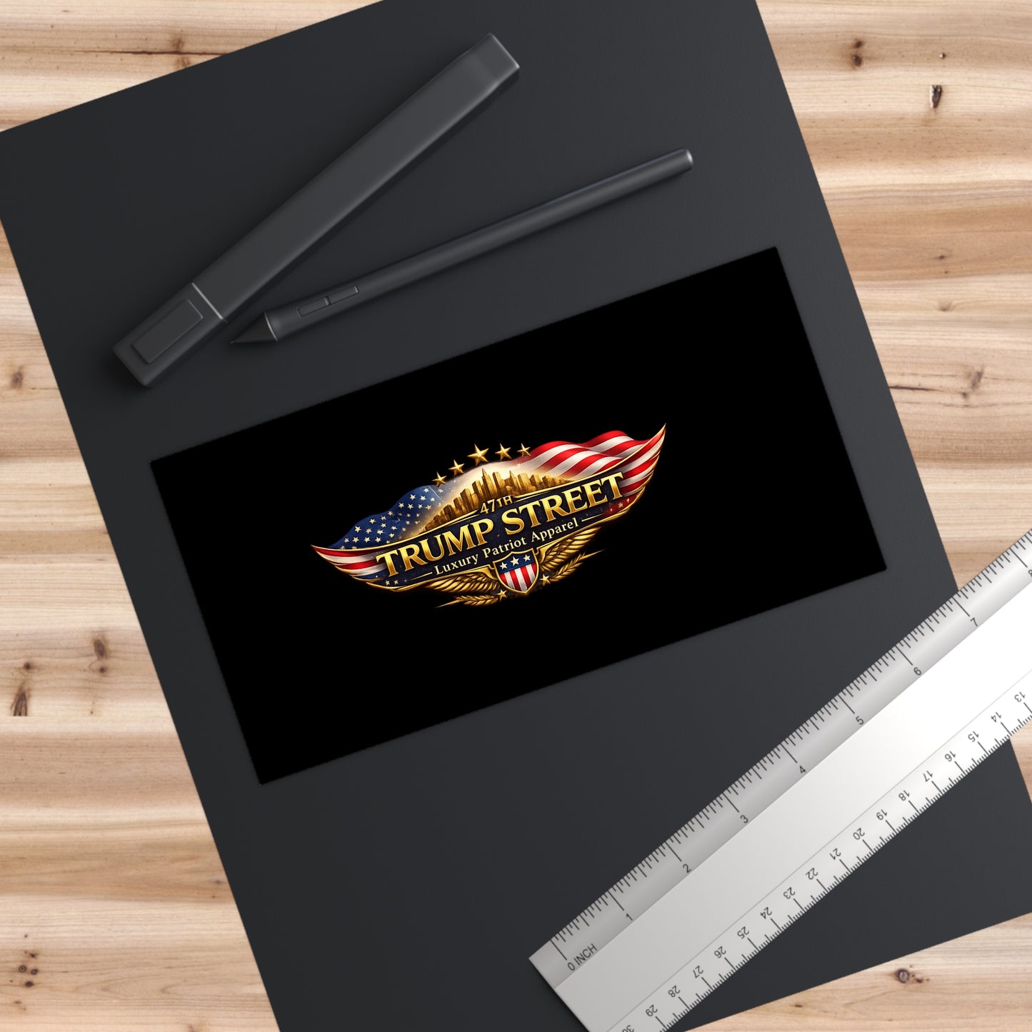 Black mat with 'Trump Street' logo on a wooden surface with a ruler.