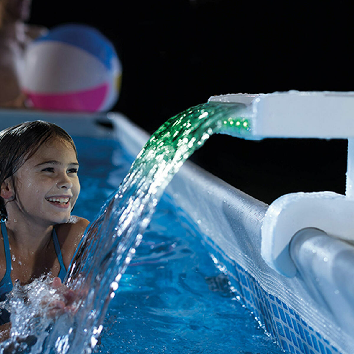 Child playing with water feature in a pool