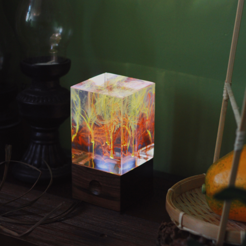 Colorful abstract light cube on a wooden base in a dimly lit room