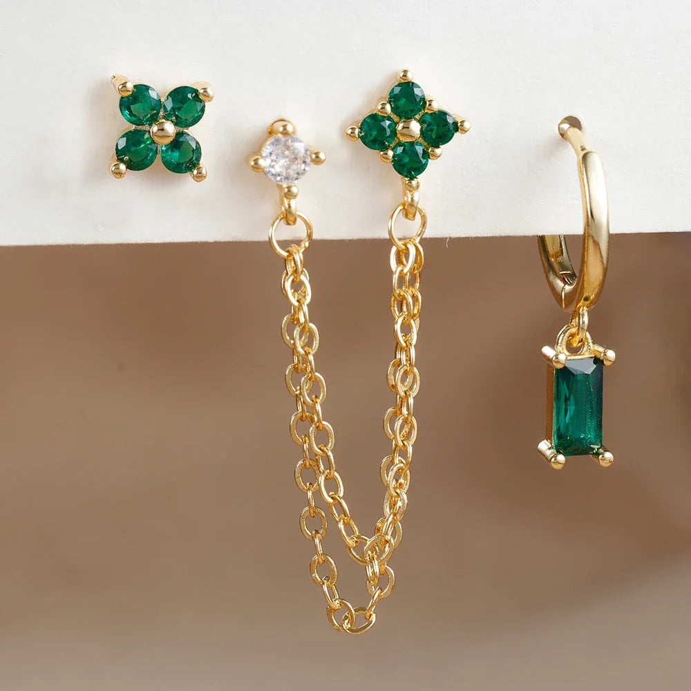 Celestial zodiac birthstone earring set in gold with gemstone accents and elegant chain detail background