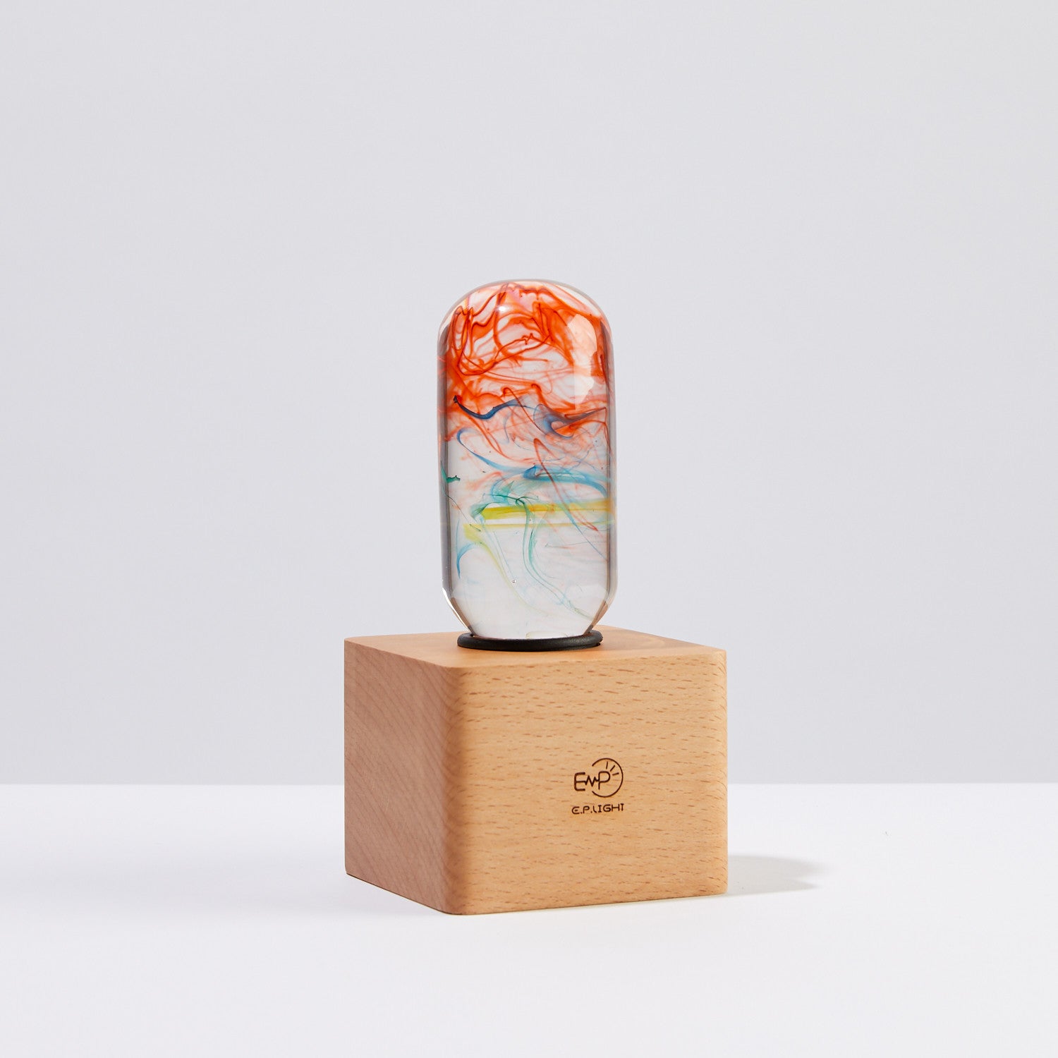 Marble-patterned cylindrical object on a wooden stand with a light gray background