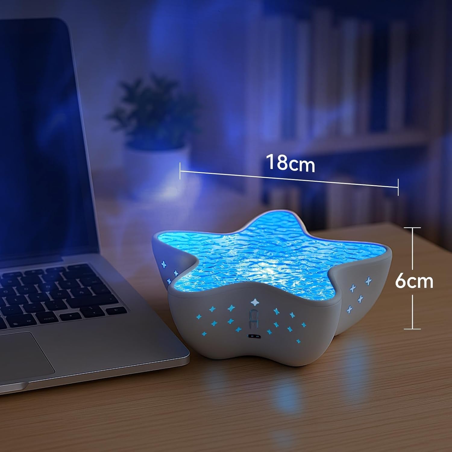 Galaxy star projector light casting blue nebula and star effects in a dark room