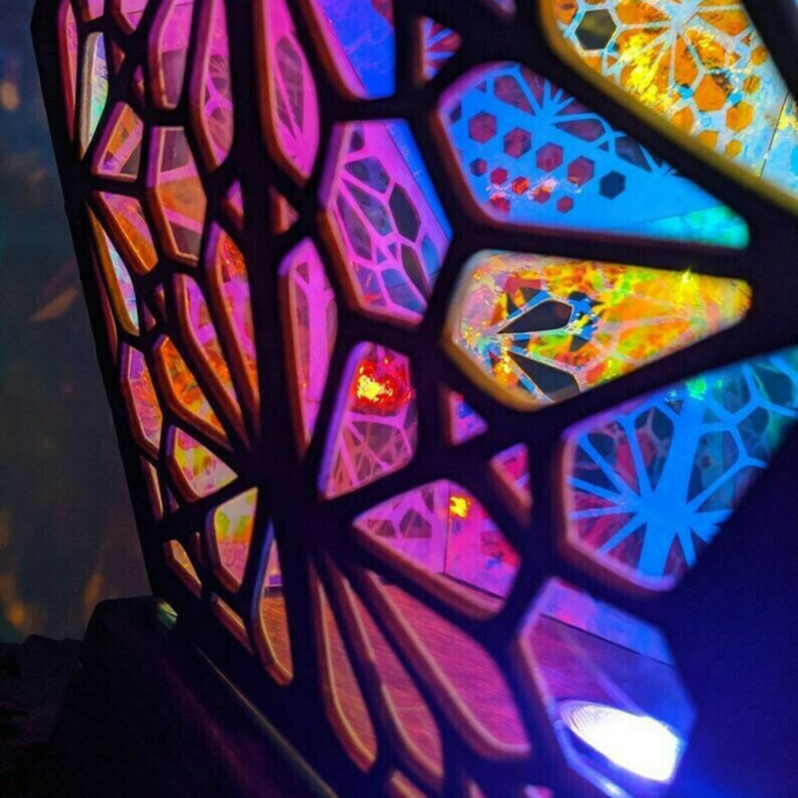 Bohemian wooden table lamp with colorful geometric stained-glass style glow on a tabletop